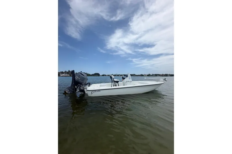 Slide: The Image of 2019 Yellowfin 21 Bay boat on calm water under a partly cloudy sky. - 27