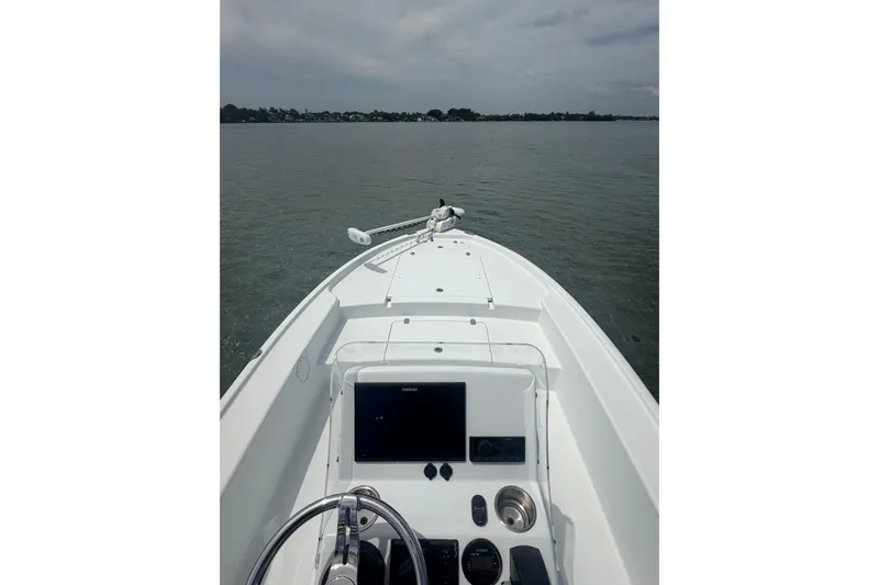 Slide: The Image of 2019 Yellowfin 21 Bay boat on calm water, featuring a sleek dashboard and open deck. - 7