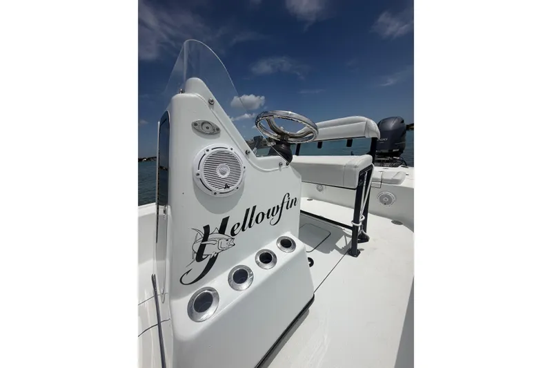 Slide: The Image of 2019 Yellowfin 21 Bay boat console with steering wheel and seating under clear sky. - 8