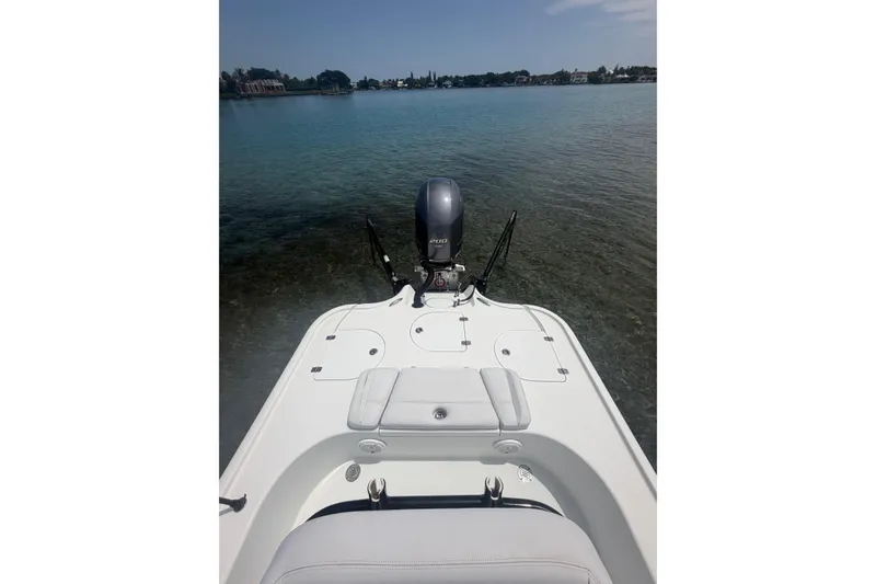 Slide: The Image of 2019 Yellowfin 21 Bay boat on calm water, showcasing sleek design and powerful engine. - 18