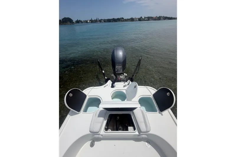 Slide: The Image of 2019 Yellowfin 21 Bay boat with open compartments, docked in clear water. - 19