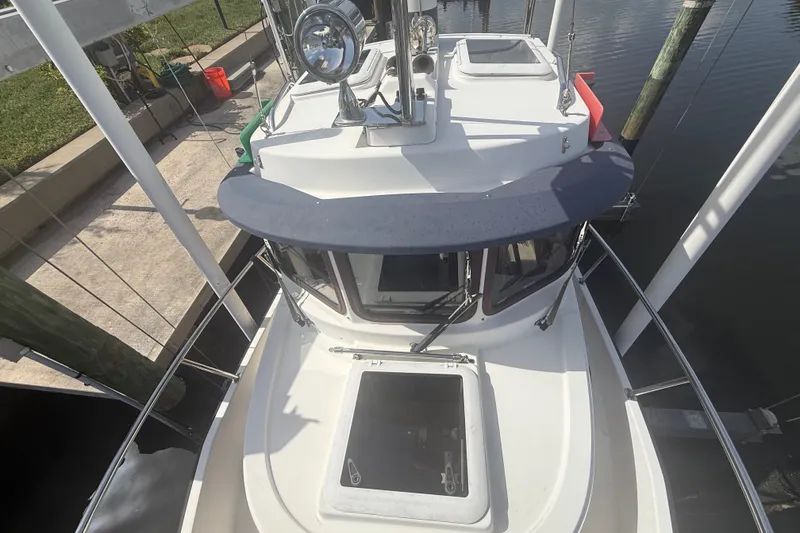 Slide: The Image of 2012 Ranger Tugs R-21 EC boat docked, top view showing cabin and deck details. - 2