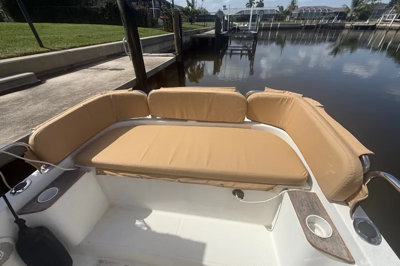 Slide: The Image of 2012 Ranger Tugs R-21 EC boat with tan cushioned seating by a dock. - 6