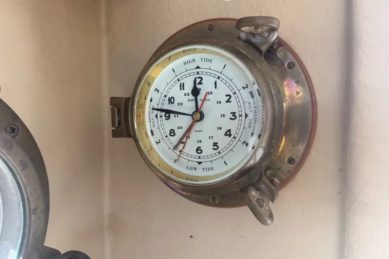 Slide: The Image of Nautical clock on 2012 Ranger Tugs R-21 EC, displaying high and low tide times. - 33