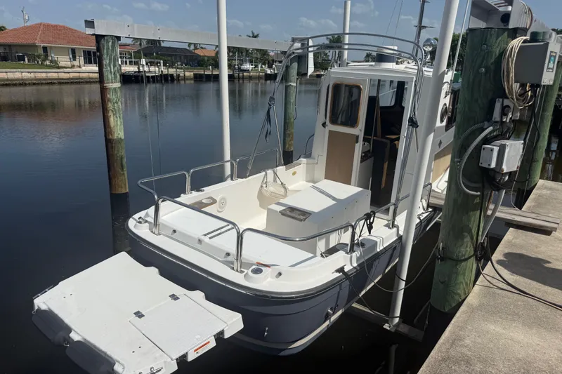 Slide: The Image of 2012 Ranger Tugs R-21 EC docked at a marina, showcasing its compact design. - 3