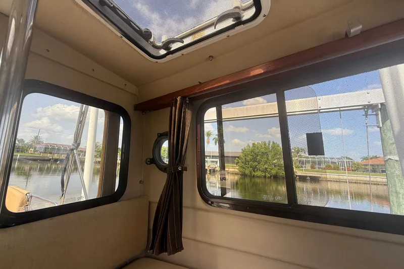 Slide: The Image of Interior view of 2012 Ranger Tugs R-21 EC boat with windows overlooking a serene waterfront. - 26