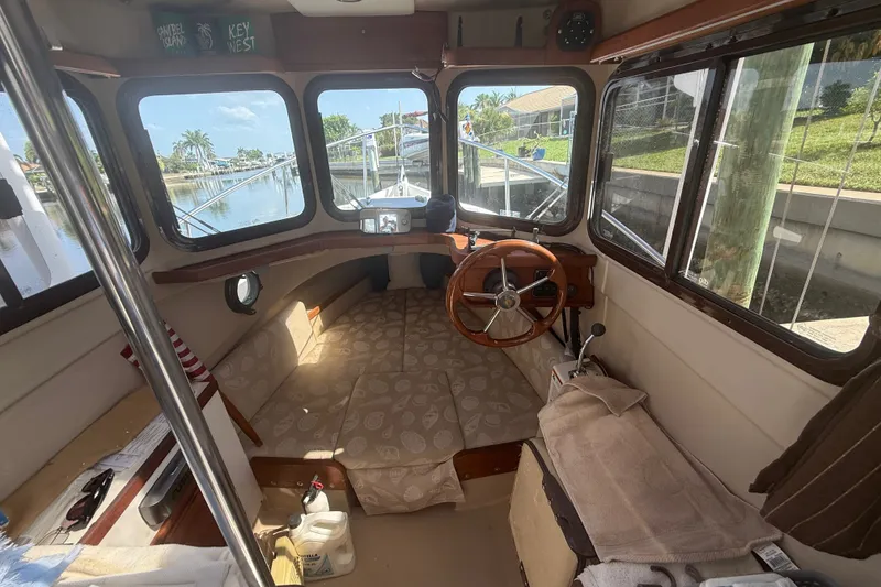 Slide: The Image of Interior of 2012 Ranger Tugs R-21 EC boat with steering wheel and seating area. - 12