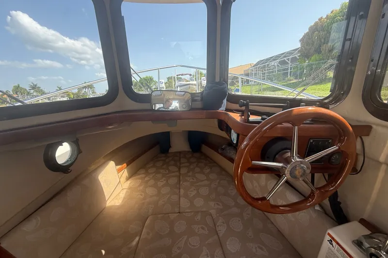 Slide: The Image of Interior of 2012 Ranger Tugs R-21 EC boat with wooden steering wheel and cozy seating. - 15