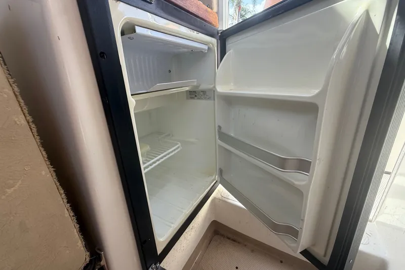 Slide: The Image of Open refrigerator inside a 2012 Ranger Tugs R-21 EC boat, showing empty shelves. - 30