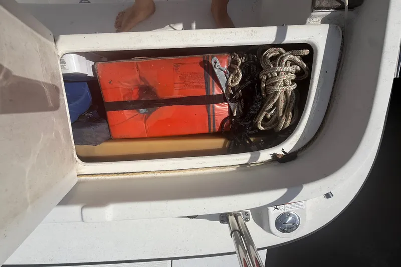 Slide: The Image of Storage compartment on a 2012 Ranger Tugs R-21 EC with ropes and a red container. - 45