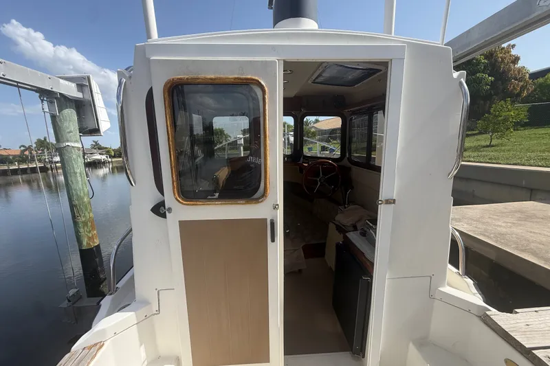 Slide: The Image of 2012 Ranger Tugs R-21 EC boat interior view at dockside, showcasing cabin entrance. - 10
