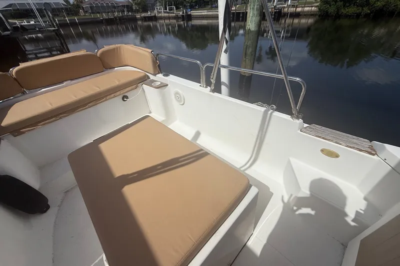 Slide: The Image of 2012 Ranger Tugs R-21 EC boat interior with tan seating, docked by calm water. - 8