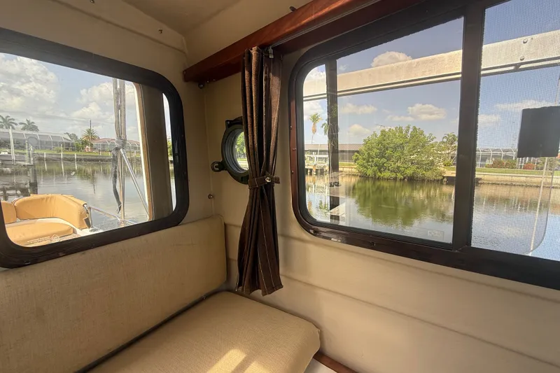 Slide: The Image of Interior view of 2012 Ranger Tugs R-21 EC, showcasing windows and waterfront scenery. - 24