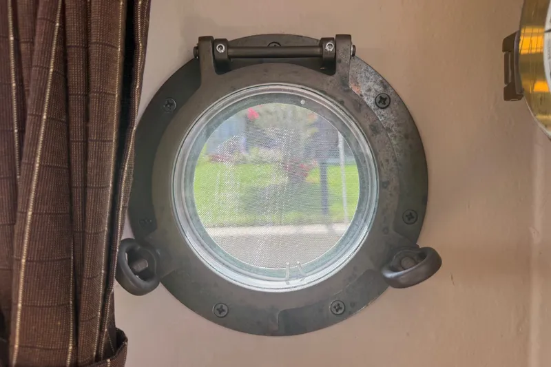 Slide: The Image of Porthole view from 2012 Ranger Tugs R-21 EC, featuring a circular window and curtain. - 34