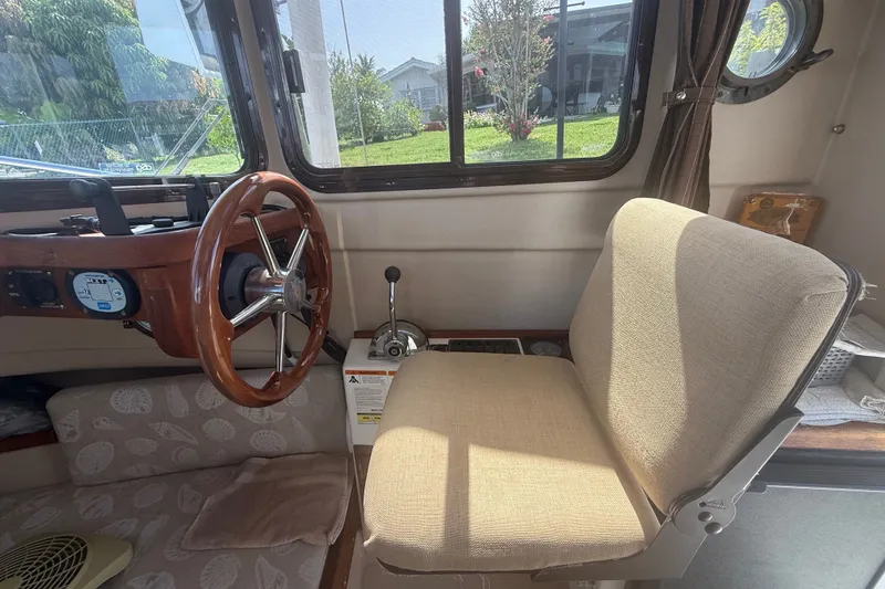 Slide: The Image of Interior of 2012 Ranger Tugs R-21 EC boat with steering wheel and beige seat. - 13
