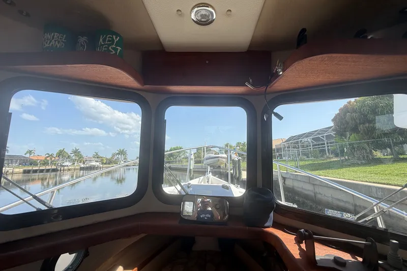 Slide: The Image of Interior view from a 2012 Ranger Tugs R-21 EC, overlooking a serene canal. - 16