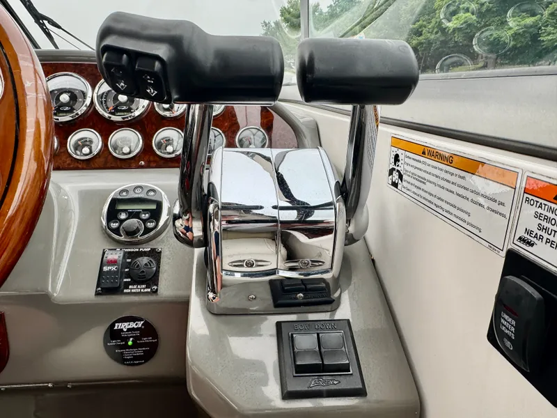 Slide: The Image of Close-up of the helm of a 2012 Regal 3550 Cuddy with throttle controls and gauges. - 28