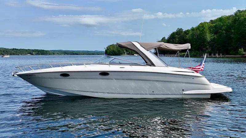Slide: The Image of 2012 Regal 3550 Cuddy on a calm lake with a wooded shoreline in the background. - 10