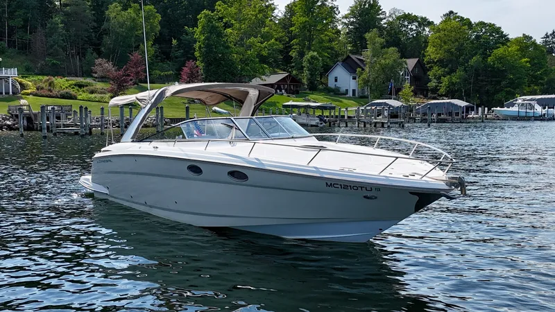 Slide: The Image of 2012 Regal 3550 Cuddy on a calm lake, surrounded by green trees and houses. - 7