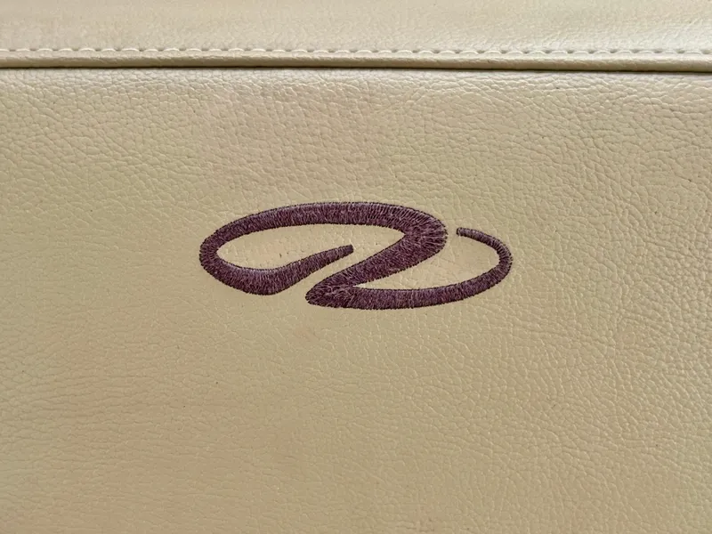 Slide: The Image of Close-up of a beige leather seat with an embroidered logo. - 40