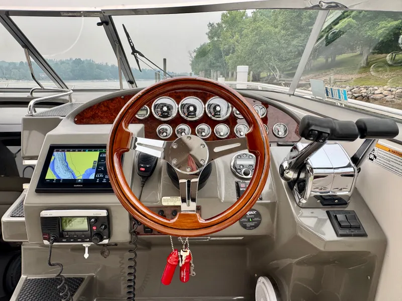 Slide: The Image of The image shows the cockpit of a 2012 Regal 3550 Cuddy with a sleek wooden steering wheel and modern instruments. - 24
