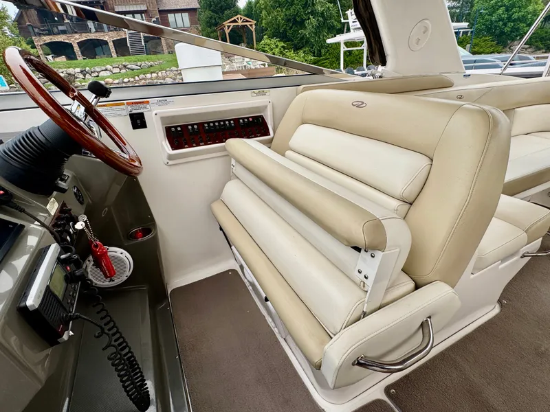Slide: The Image of Interior of a 2012 Regal 3550 Cuddy with beige seating and a helm console. - 23
