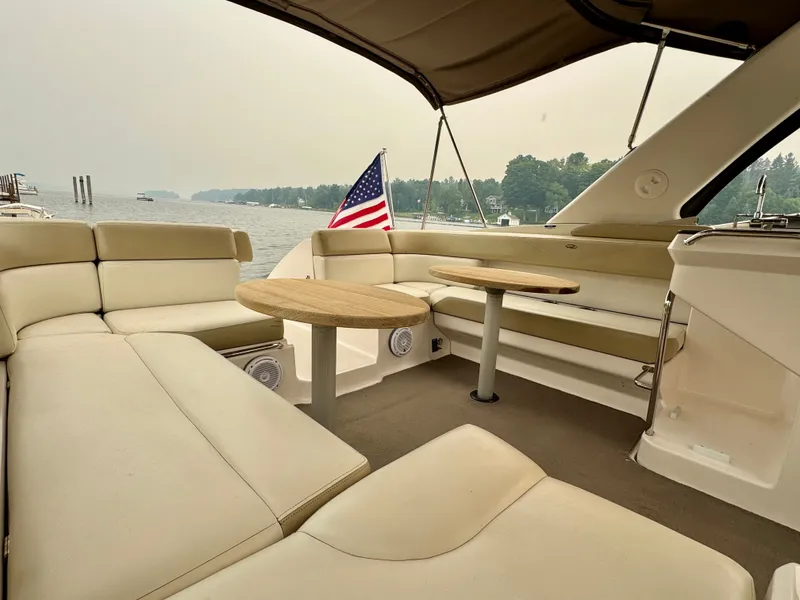 Slide: The Image of The image shows the cockpit of a 2012 Regal 3550 Cuddy with beige upholstery and wooden tables. - 19
