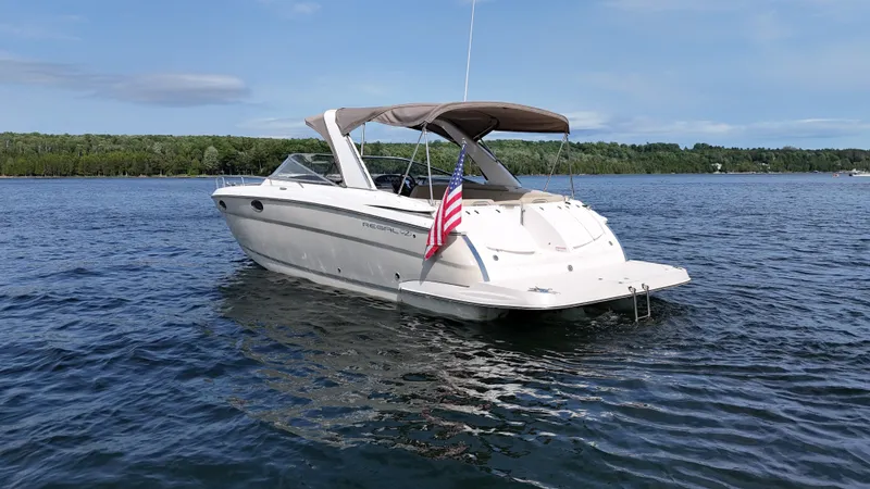 Slide: The Image of 2012 Regal 3550 Cuddy on a calm lake with a wooded shoreline in the background. - 11