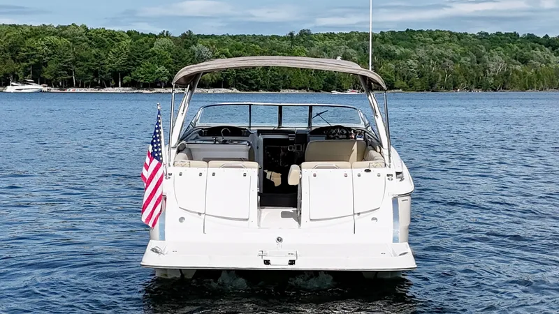Slide: The Image of Rear view of a 2012 Regal 3550 Cuddy boat on a lake with a US flag. - 4