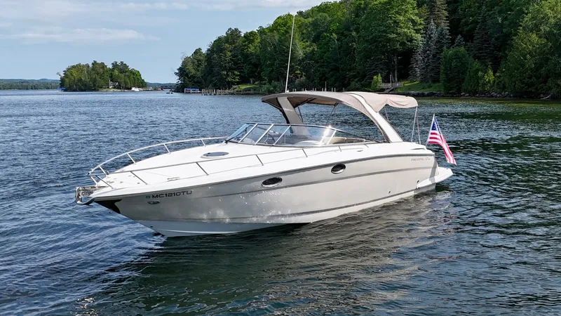 Slide: The Image of A 2012 Regal 3550 Cuddy boat on a calm lake with a wooded shoreline. - 13