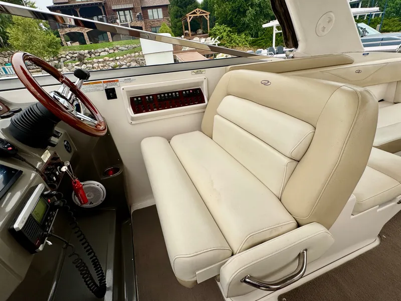 Slide: The Image of Interior of a 2012 Regal 3550 Cuddy with beige seating and a helm console. - 22