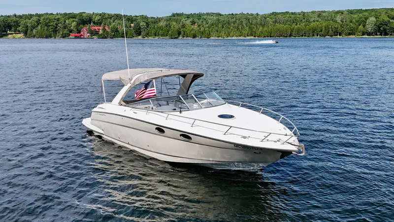 Slide: The Image of 2012 Regal 3550 Cuddy on a calm lake with a wooded shoreline in the background. - 14
