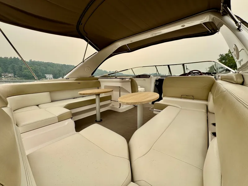 Slide: The Image of The image shows the spacious cockpit of a 2012 Regal 3550 Cuddy with beige seating and wooden tables. - 1