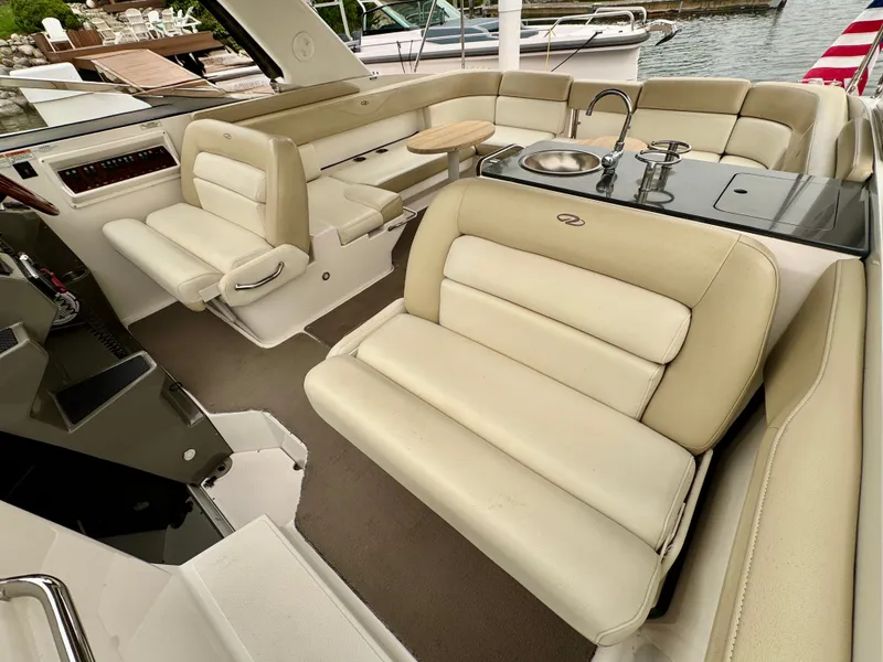 Slide: The Image of The image shows the cockpit of a 2012 Regal 3550 Cuddy with beige leather seating and a small sink. - 32
