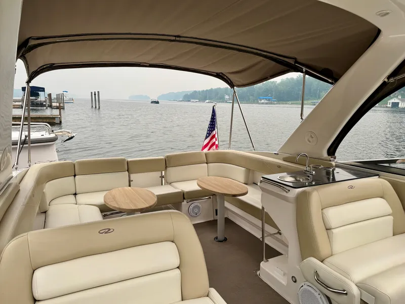 Slide: The Image of 2012 Regal 3550 Cuddy with spacious cockpit, comfortable seating, tables, and a small kitchenette by the lake. - 39
