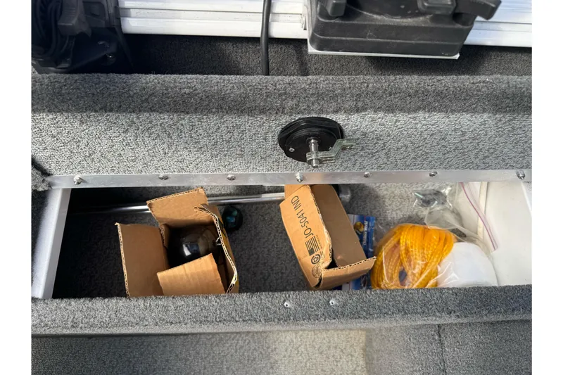 Slide: The Image of Storage compartment in a 2011 Lund 1625 Rebel XL Sport boat with boxes and rope. - 17