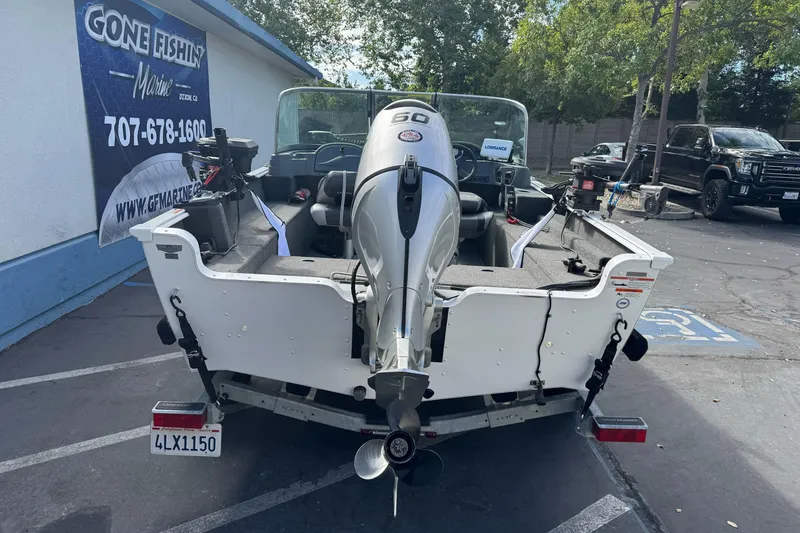 Slide: The Image of 2011 Lund 1625 Rebel XL Sport boat with outboard motor in parking lot. - 5