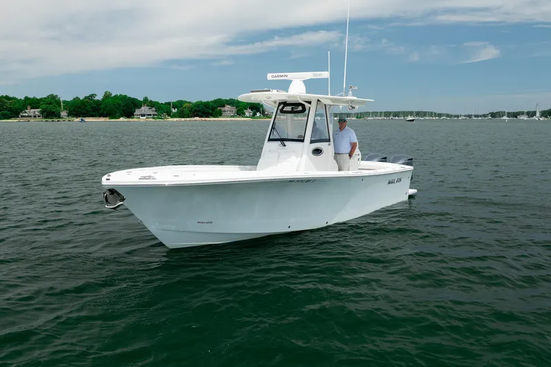 Slide: The Image of 2021 Regulator 28 Forward Seating boat on calm water, featuring sleek design and modern amenities. - 2