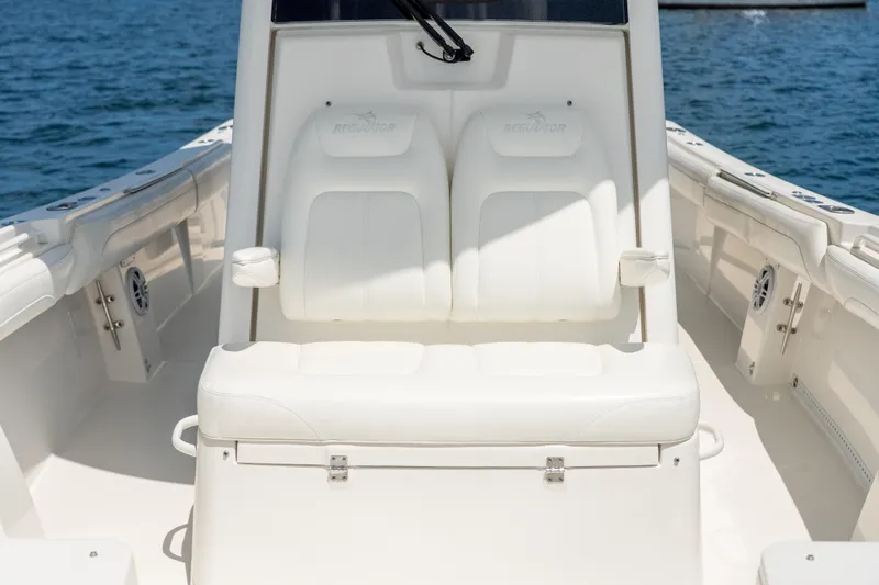 Slide: The Image of 2021 Regulator 28 Forward Seating boat with white cushioned seats on open water. - 12