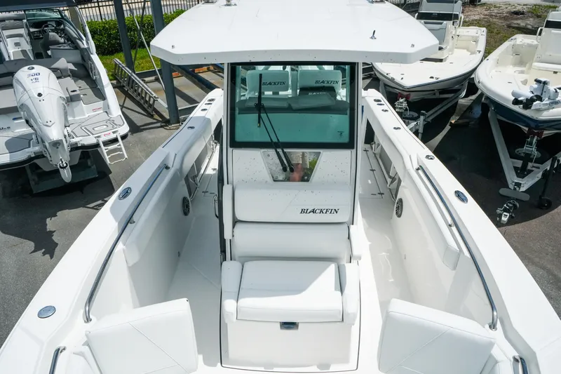 Slide: The Image of 2019 Blackfin 272 CC boat, white interior, docked among other boats. - 22