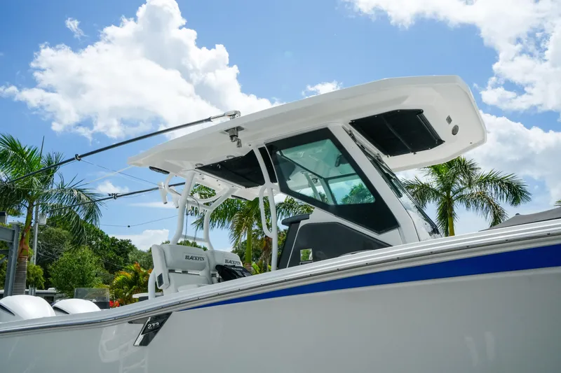 Slide: The Image of 2019 Blackfin 272 CC boat with T-top, set against a tropical backdrop and blue sky. - 6