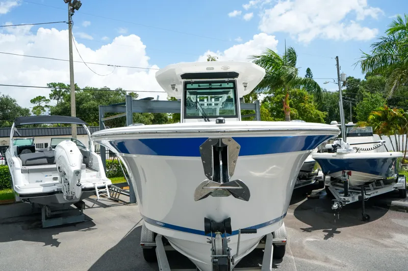 Slide: The Image of 2019 Blackfin 272 CC boat displayed outdoors with palm trees and blue sky. - 4