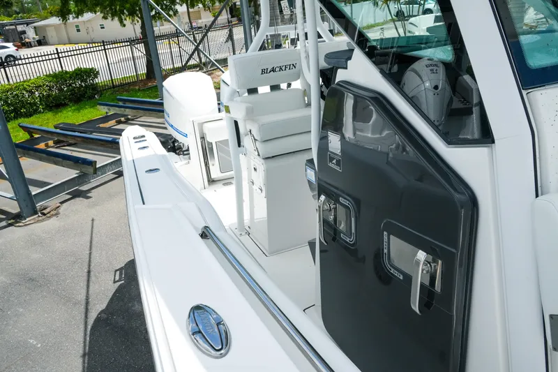 Slide: The Image of 2019 Blackfin 272 CC boat, white exterior, docked with visible seating and storage compartments. - 23