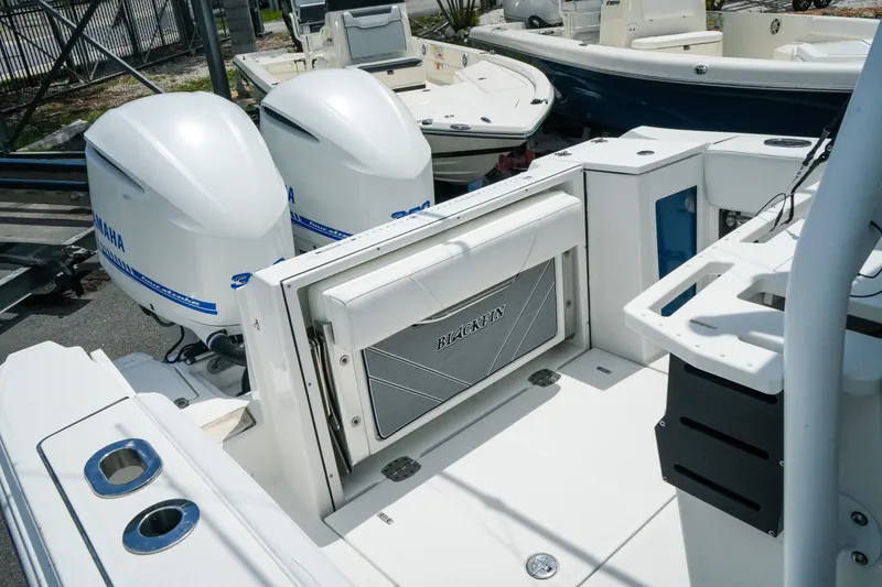 Slide: The Image of 2019 Blackfin 272 CC boat with dual Yamaha outboard engines, docked at a marina. - 25