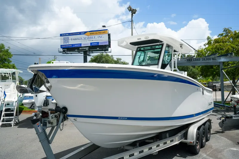Slide: The Image of 2019 Blackfin 272 CC boat on trailer, displayed outdoors under a cloudy sky. - 3