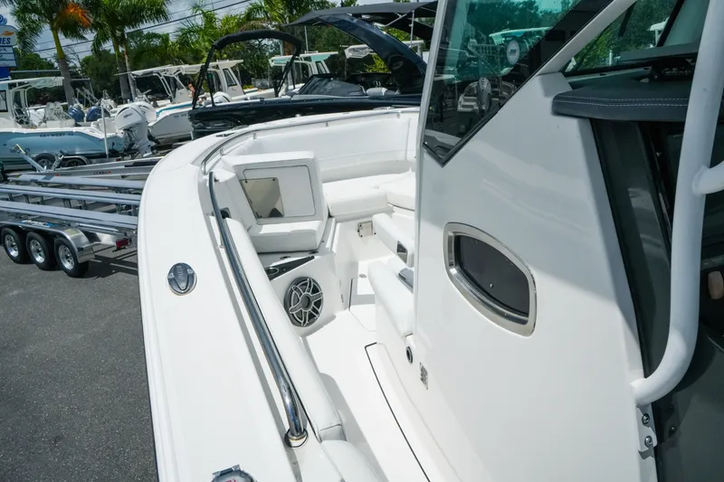 Slide: The Image of 2019 Blackfin 272 CC boat interior with seating and speaker, parked outdoors. - 18