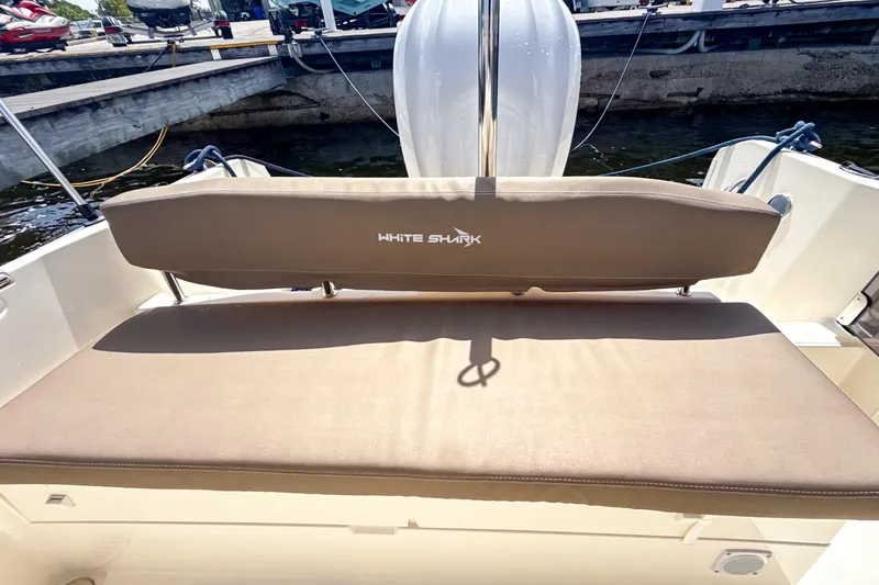 Slide: The Image of 2023 White Shark 230CC boat with beige seating at a marina dock. - 13