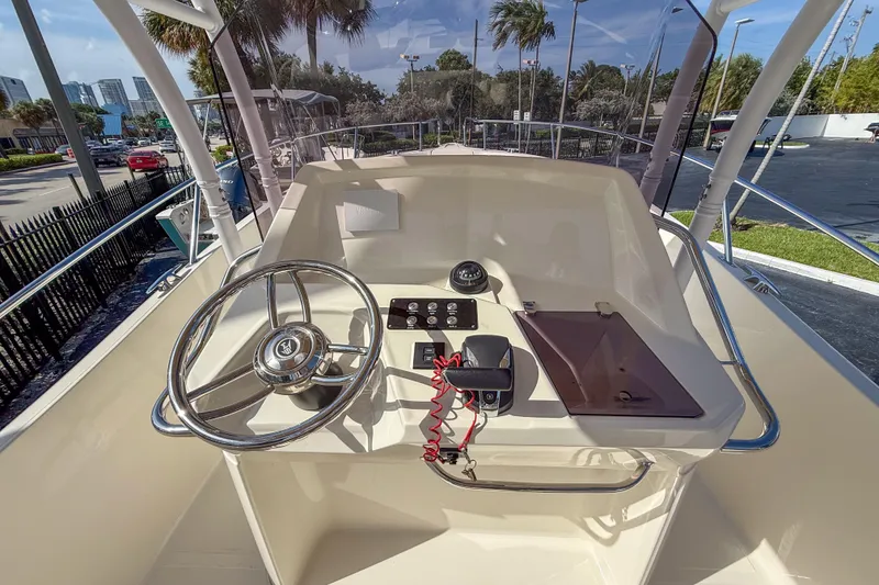 Slide: The Image of 2023 White Shark 230CC boat helm with steering wheel and control panel. - 11