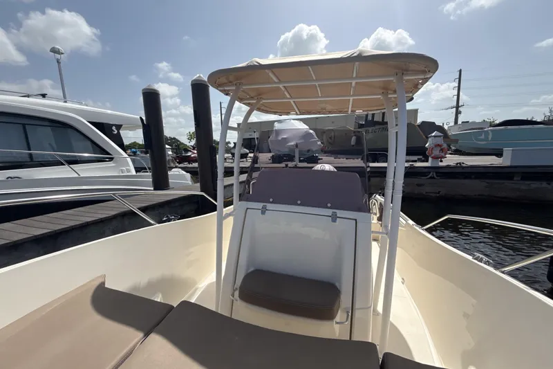 Slide: The Image of 2023 White Shark 230CC boat docked, featuring a shaded seating area under a canopy. - 4