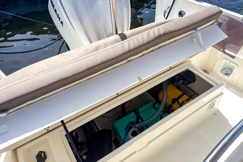 Slide: The Image of 2023 White Shark 230CC boat storage compartment with open seat, revealing equipment inside. - 14